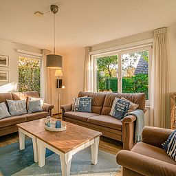 Cozy living room of Holiday home Honeysuckle 65 in De Koog, Texel, with comfortable sofas.