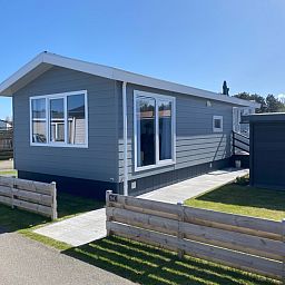 Sunny exterior of Chalet Bregkoog 94 on Chaletpark Bregkoog, De Koog, Texel.