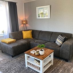 Dining room in Chalet Bregkoog 94, De Koog, Texel with wooden table and blue chairs at Chaletpark Bregkoog.