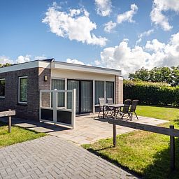 Ferienhaus Bungalow 19A in De Koog, Texel mit grossem Aussenbereich und bequemen Sitzgelegenheiten auf der Terrasse.