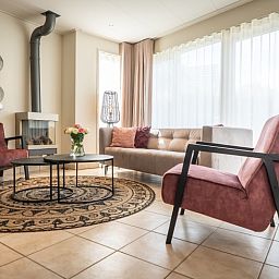 Gemuetliches Wohnzimmer von Bungalow 19A in De Koog, Texel mit bequemen Sitzgelegenheiten und viel Tageslicht.