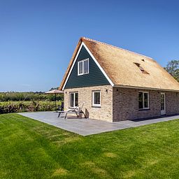 Side view of Landhuis De Wije Blick, vacation home in De Koog, Texel, with sunny garden and terrace.
