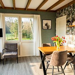 Dining area in De Koperwiek vacation home De Koog Texel with natural light and views.