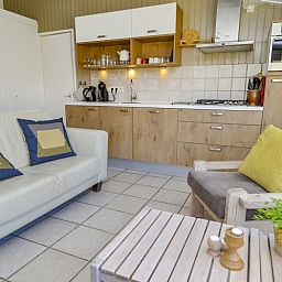 Moderne Kueche im Ferienhaus Achter de Brem, De Koog, Texel, mit gemuetlicher Sitzecke.