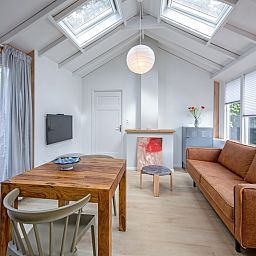 Ess- und Sitzecke im Ferienhaus Pippa, gelegen in De Koog, Texel, mit Zugang zum Garten.