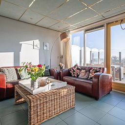 Cozy living room of Resort De Buteriggel - Apartment 9, De Koog, Texel with comfortable sofas and views of nature.