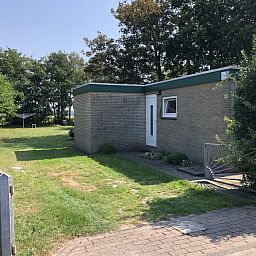 Entrance to Bungalow Oud Vredelust 85 in De Koog, Texel, surrounded by nature.