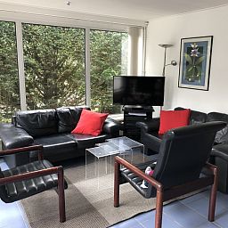 Cozy living room in Bungalow Oud Vredelust 85, De Koog, Texel with comfortable furniture.