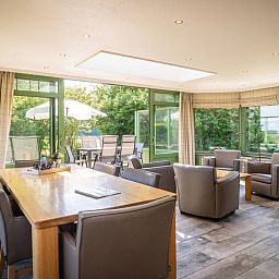 Geraeumiges Esszimmer in der Villa mit Wintergarten, De Koog, Texel, umgeben von Gruen, ideal fuer Urlaubsessen.