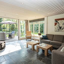 Cozy indoor area of Westenwind in De Koog, Texel with spacious sofa and access to the garden.