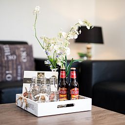 Gemuetliche Sitzecke in Villa 2, De Koog Texel, mit lokalen Texeler Bieren und stilvoller Einrichtung.