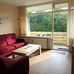 't Kerckeland - Apartment Kerckeland 86, De Koog, Texel: sunny living room with large windows and views of the green landscape.