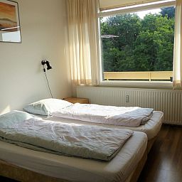 't Kerckeland - Apartment Kerckeland 86, De Koog, Texel: bright bedroom with two single beds and a beautiful view of nature.