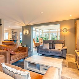 Helles Wohnzimmer des Huis ter Duin, Ferienhaus in De Koog, Texel mit grossen Fenstern.