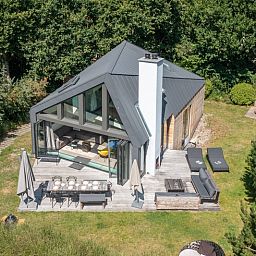 Enjoy the serene garden surrounding Duynzoom Villa 5, a vacation home in De Koog, Texel, perfect for a relaxing stay.