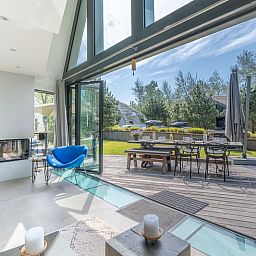 Bright interior space of Duynzoom Villa 5 in De Koog, Texel, overlooking the terrace and green surroundings.