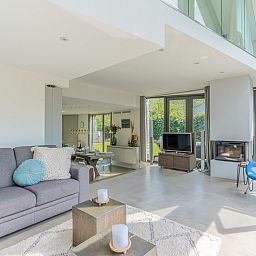 Modern living room of Duynzoom Villa 5, a vacation home in De Koog, Texel, with comfortable furnishings and lots of light.
