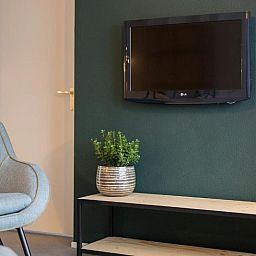 Gemuetliche Sitzecke im Apartment 4 bis 6 Personen, De Koog, Texel mit Flachbildfernseher und moderner Einrichtung.