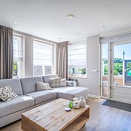 Bright living room of Apartment Juliana 034 Eilandzicht, De Koog, Texel with spacious seating area and access to the terrace.