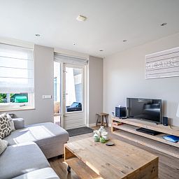 Stylish living room in Apartment Juliana 034 Eilandzicht, De Koog, Texel with flat-screen TV and access to outdoor space.