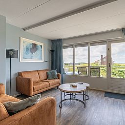Helles Wohnzimmer der Ferienwohnung Juliana 096 Insel- und Meerblick, De Koog, Texel mit moderner Einrichtung und Meerblick.