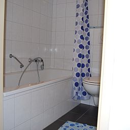 Modern bathroom in Apartment Dorpsstraat 245, De Koog, Texel with bathtub and shower.