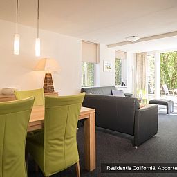 Cozy dining room in Type 4 accommodation, De Koog, Texel. Modern decor with green accents.