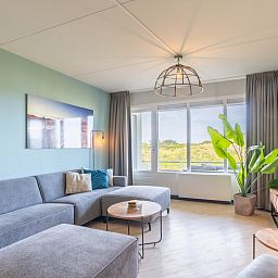 Moderne Sitzecke im Appartement Juliana 044 Insel- und Meerblick, De Koog, Texel mit bequemem Sofa.
