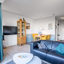 Modern seating area in Apartment Juliana 068 Island and Sea View, De Koog, Texel with flat-screen TV and dining area.