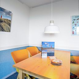 Dining area with colorful chairs in Apartment Juliana 068 Island and Sea View, De Koog, Texel.
