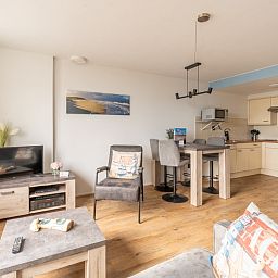 Geraeumiges Wohn- und Esszimmer von Apartment Juliana 076 Eilandzicht, De Koog, Texel, mit moderner Einrichtung und viel Licht.