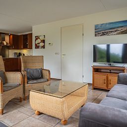 Cozy sitting area in Villa 304, De Koog, Texel with modern furnishings and television for relaxation.