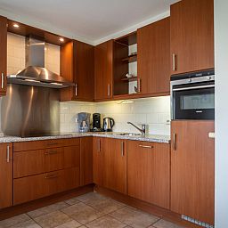 Modern kitchen in Villa 304, De Koog, Texel with wooden cabinets and complete kitchen appliances.
