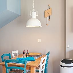 Dining area in Landgoed Springtij - Koetshuis 3, vacation home De Koog, Texel with wooden table and colorful chairs.