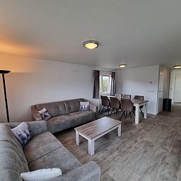 Stylish indoor area of Chaletpark Bregkoog - Chalet 240 De Texelse Berg, De Koog, Texel with sitting area and dining area.