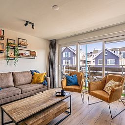 Helles Wohnzimmer im Appartement Anna 220, De Koog, Texel mit moderner Einrichtung und Balkonblick.