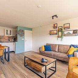 Offene Kueche und Wohnzimmer im Appartement Anna 220, De Koog, Texel mit Essecke und gemuetlicher Atmosphaere.