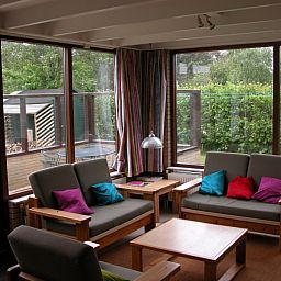 Sunny conservatory in Bungalow Oud Vredelust 75, De Koog, Texel, overlooking the garden.