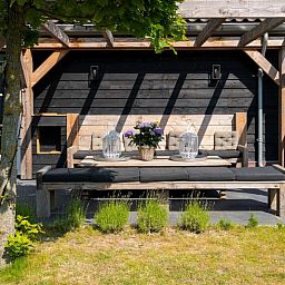 Gezellig terras bij Residence Rustiek in De Koog, Texel met zitbank en tafels.