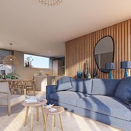 Bright living room in Duinvilla Wellness 6, Texel, with comfortable sofa and wooden wall decoration.