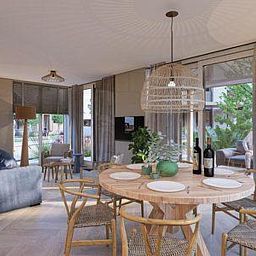 Dining room of Duinvilla Wellness 6, Texel, with round wooden table and stylish chairs.