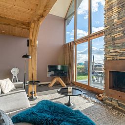 Comfortable sitting area with fireplace in Holiday home in De Koog Texel, overlooking the Wadden Islands garden.