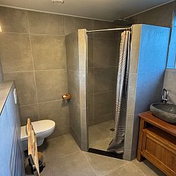 Stylish bathroom in Stormvogel, vacation home De Koog, Texel with walk-in shower and sink.