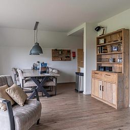 Esszimmer und Leseecke im Ferienhaus in De Waal, Texel, ideal fuer gemuetliche Mahlzeiten und entspannende Momente.