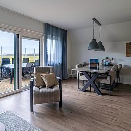 Offener Wohn- und Essbereich im Ferienhaus in De Waal, Texel mit Zugang zur Terrasse und Blick auf die Landschaft.