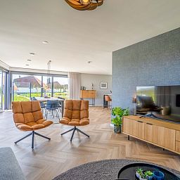 Open leefruimte in Villa 24 Oosterkolk, De Waal, Texel met veel natuurlijke lichtinval.