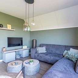 Stilvolle Sitzecke im Ferienhaus in De Waal, Texel mit moderner Einrichtung und Flachbildfernseher zur Entspannung.