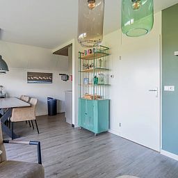 Essecke im Ferienhaus in De Waal, Texel, mit grossem Tisch und stilvollen Stuehlen, ideal fuer Familienabende.