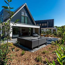 Terrasse des Ferienhauses in Den Burg, Texel, mit bequemen Sitzgelegenheiten.