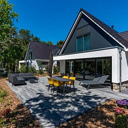 Elektroladestation am Ferienhaus in Den Burg, Texel, in gruener Umgebung.